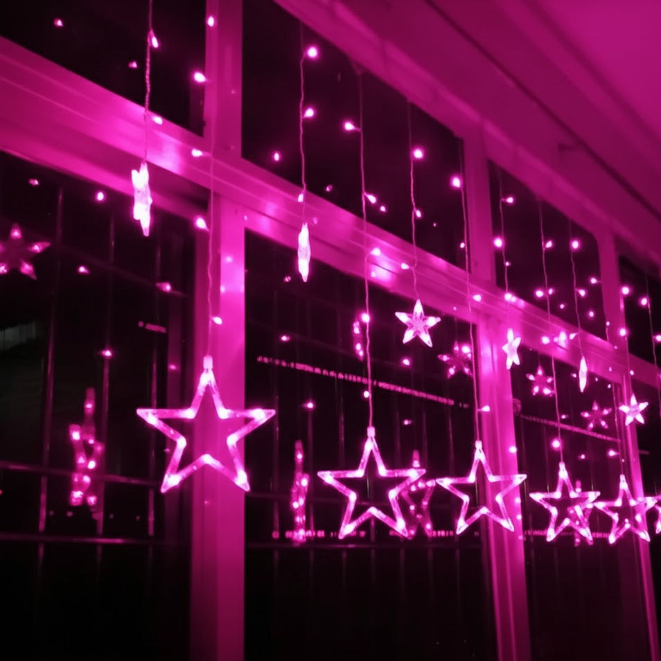 Pink star-shaped lights on a window at night