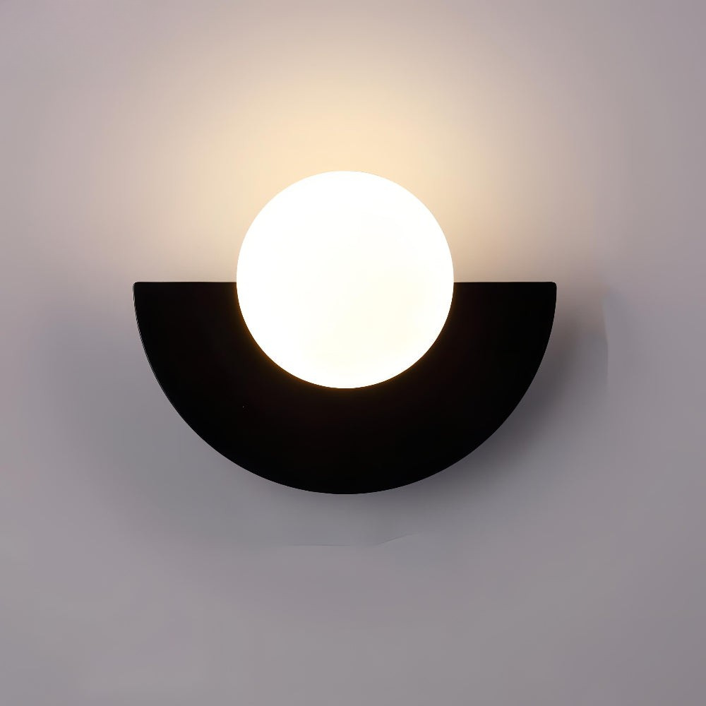 Wall-mounted light fixture with a black semi-circular base and white circular light bulb on a gray background