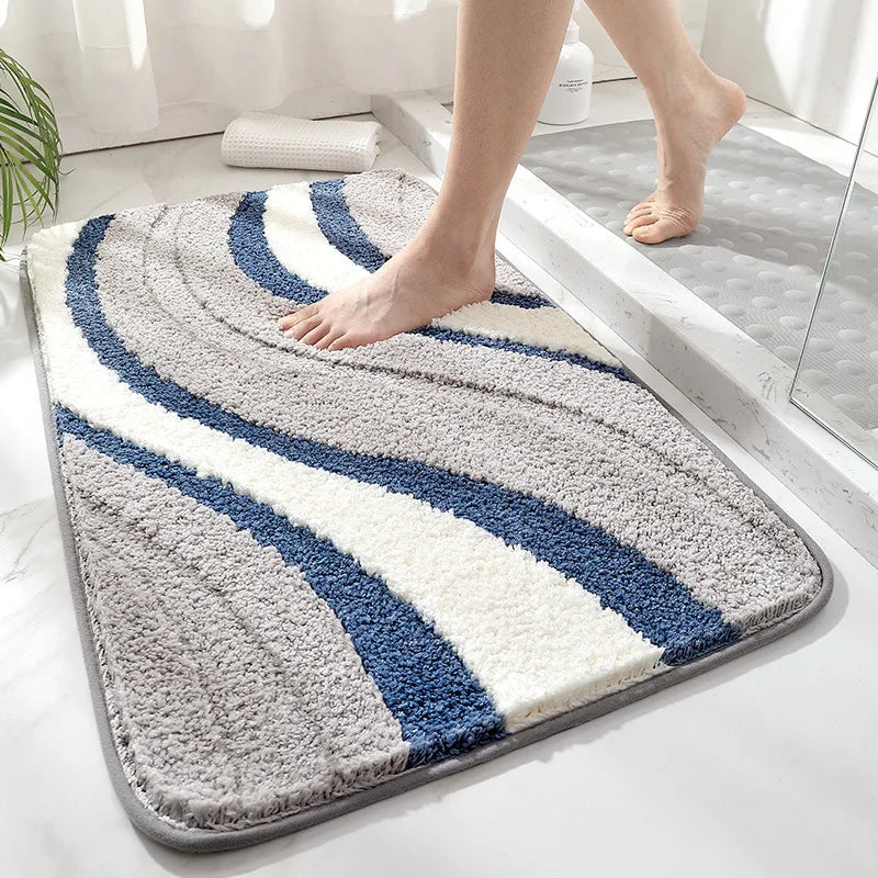 Bath mat with blue and gray stripes on a bathroom floor.