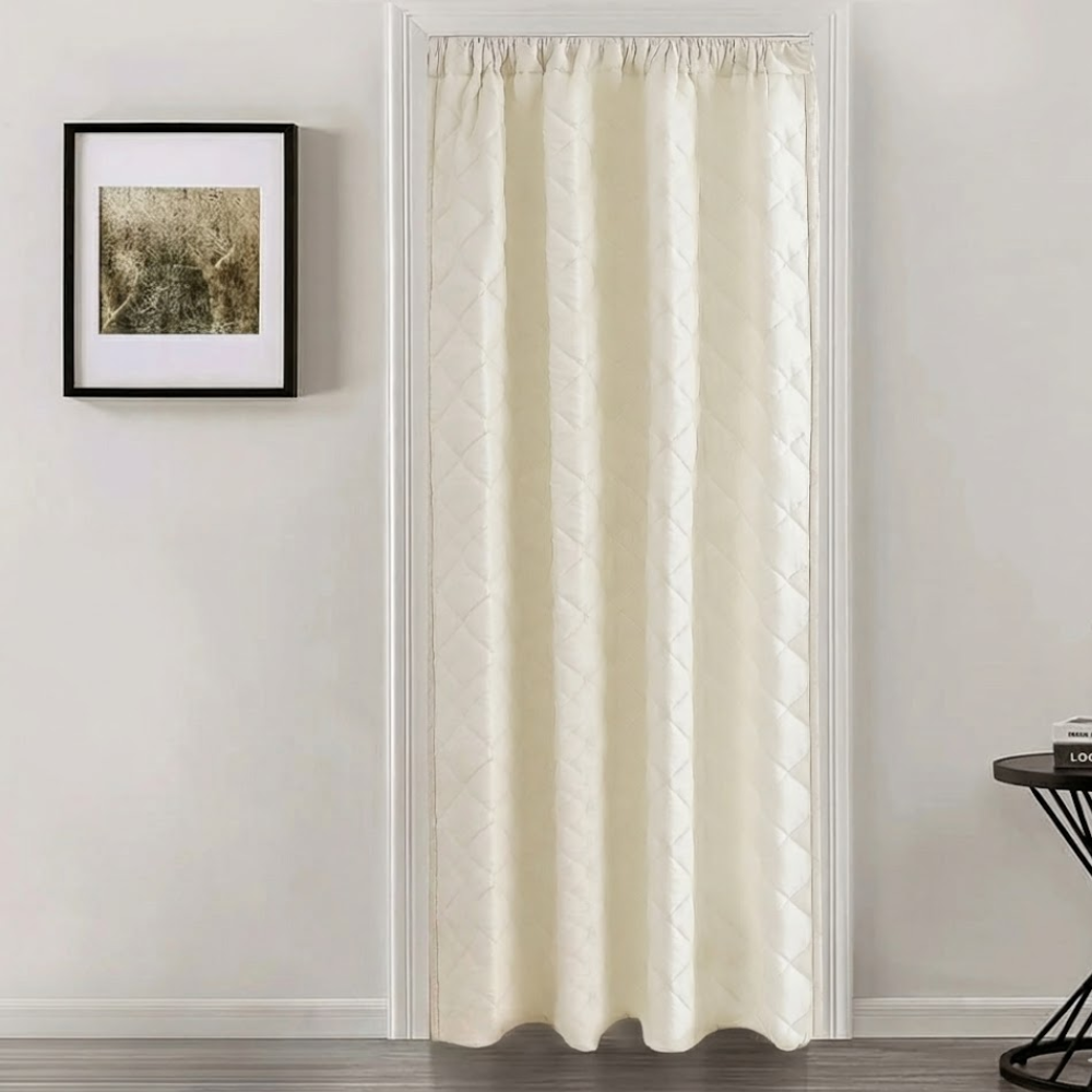 Beige curtain hanging in a room with a framed picture on the wall.