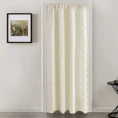 Beige curtain hanging in a room with a framed picture on the wall.