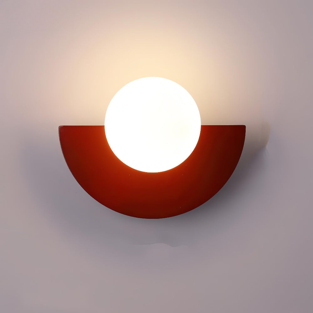 Modern wall light fixture with a red semi-circular base on a plain background