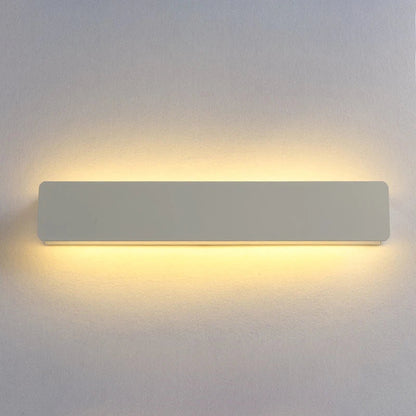 Rectangular wall light fixture on a plain wall with a soft glow.