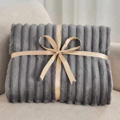 Gray blanket with a beige ribbon on a beige couch