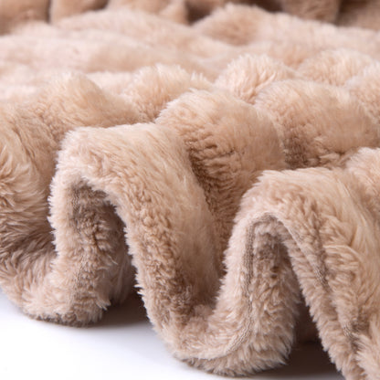 Close-up of beige plush blanket with soft texture