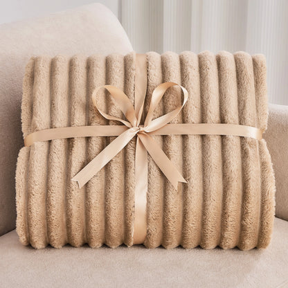 Beige blanket with a ribbon on a light-colored couch