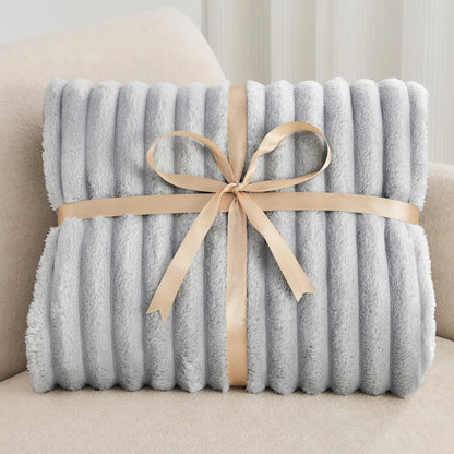 Gray blanket with a beige ribbon on a light-colored couch