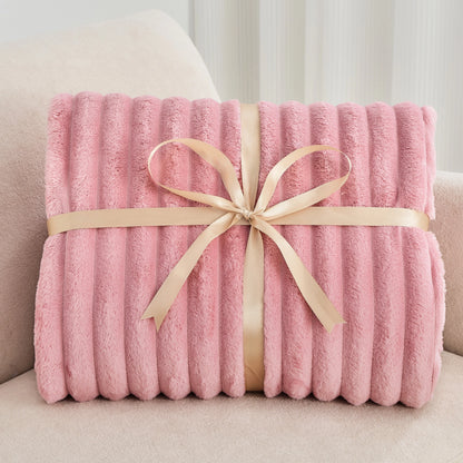 Pink blanket with a beige ribbon on a light-colored couch
