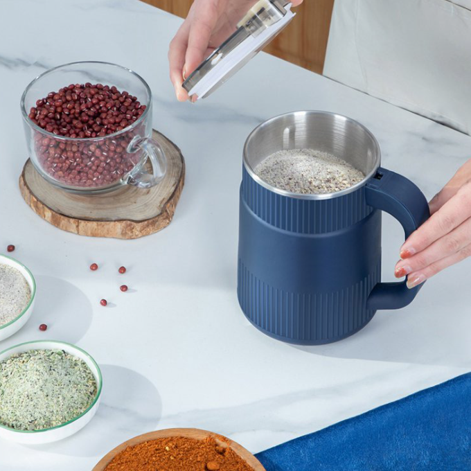 Blue mug with a metal liner on a table with various spices and ingredients.