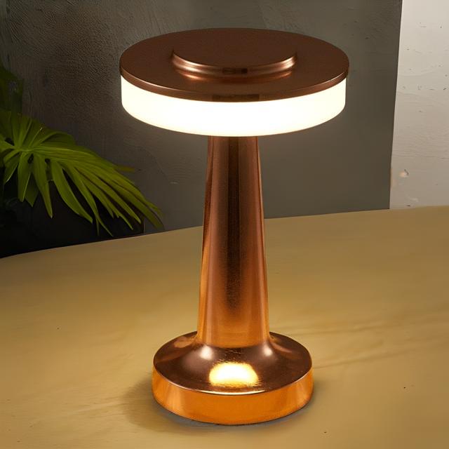 Copper-colored lamp on a beige surface with a dark background