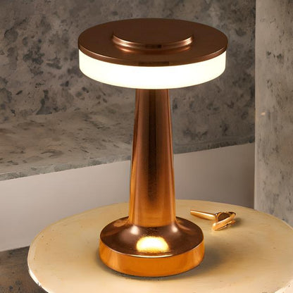 Copper-colored lamp on a wooden surface with a concrete wall background
