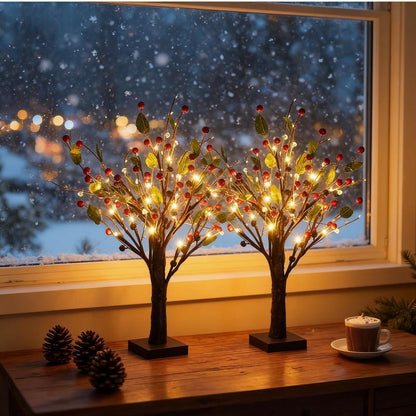 Decorative LED trees on a table with a snowy window background