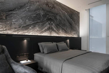 Modern bedroom with gray bedding and a large abstract wall art piece.