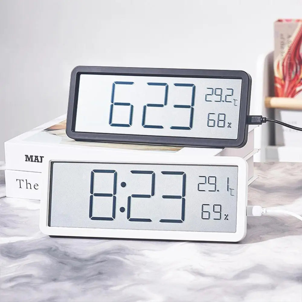 Digital clock with temperature and humidity display on a marble surface