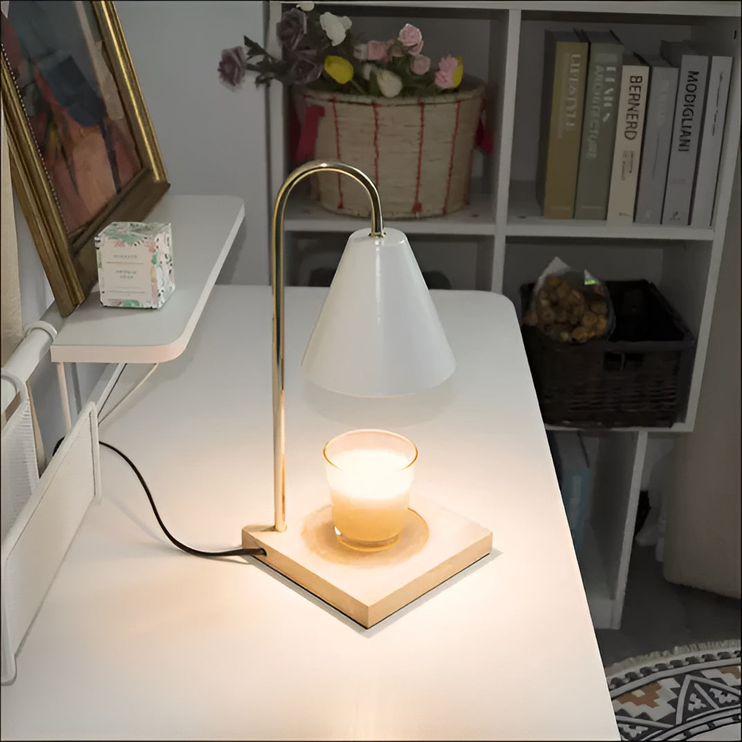 Table lamp with a white shade and wooden base on a desk, with books and decor items in the background.