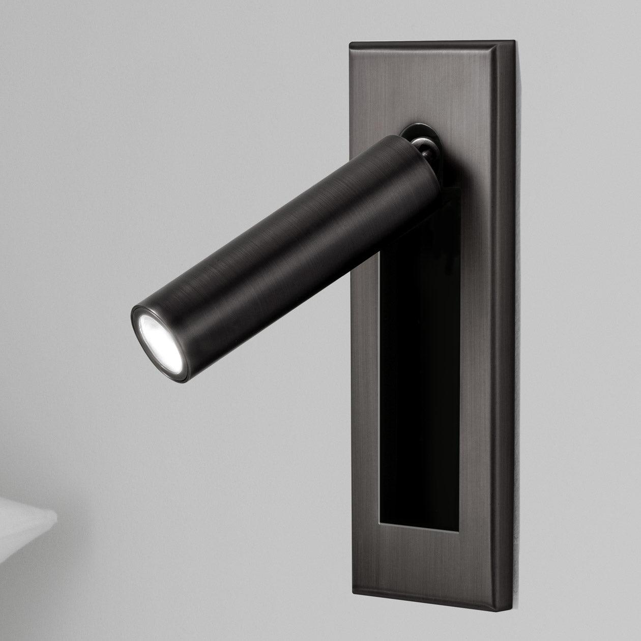 Modern wall-mounted light fixture with a rectangular base on a gray background