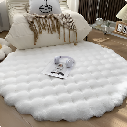 White fluffy rug on a wooden floor with a pillow and headphones on top