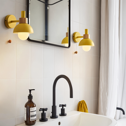 Bathroom interior with yellow wall lights, black faucet, and white sink.