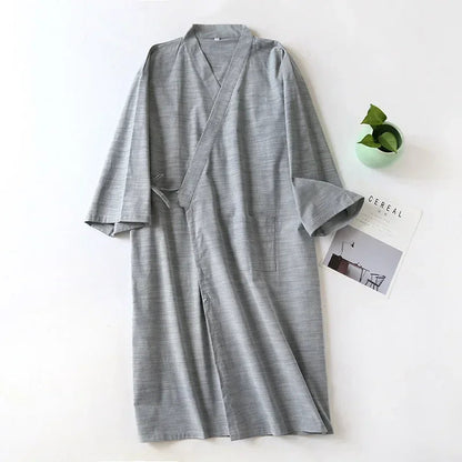 Gray robe on a white surface with a plant and magazine in the background