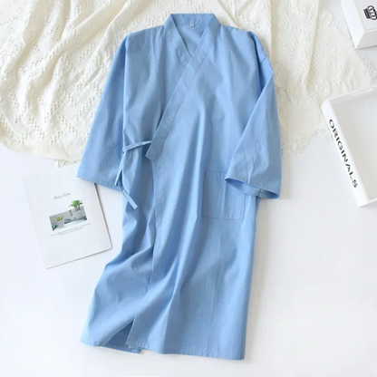 Light blue robe on a textured white surface with a magazine underneath