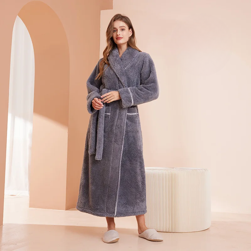 Woman wearing a gray robe in a room with a white ottoman and archway.