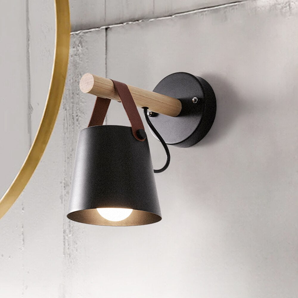 Wall-mounted lamp with black shade and wooden arm on a light gray wall.