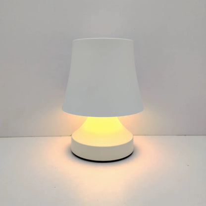 Small table lamp with a white shade and base on a light gray background