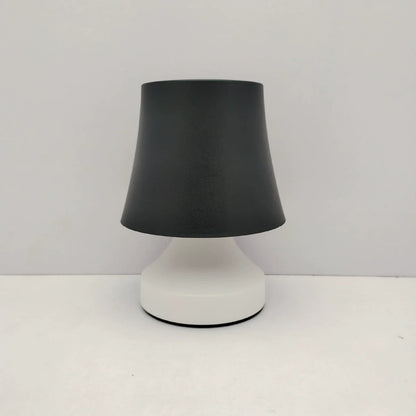 Table lamp with black shade and white base on a white background