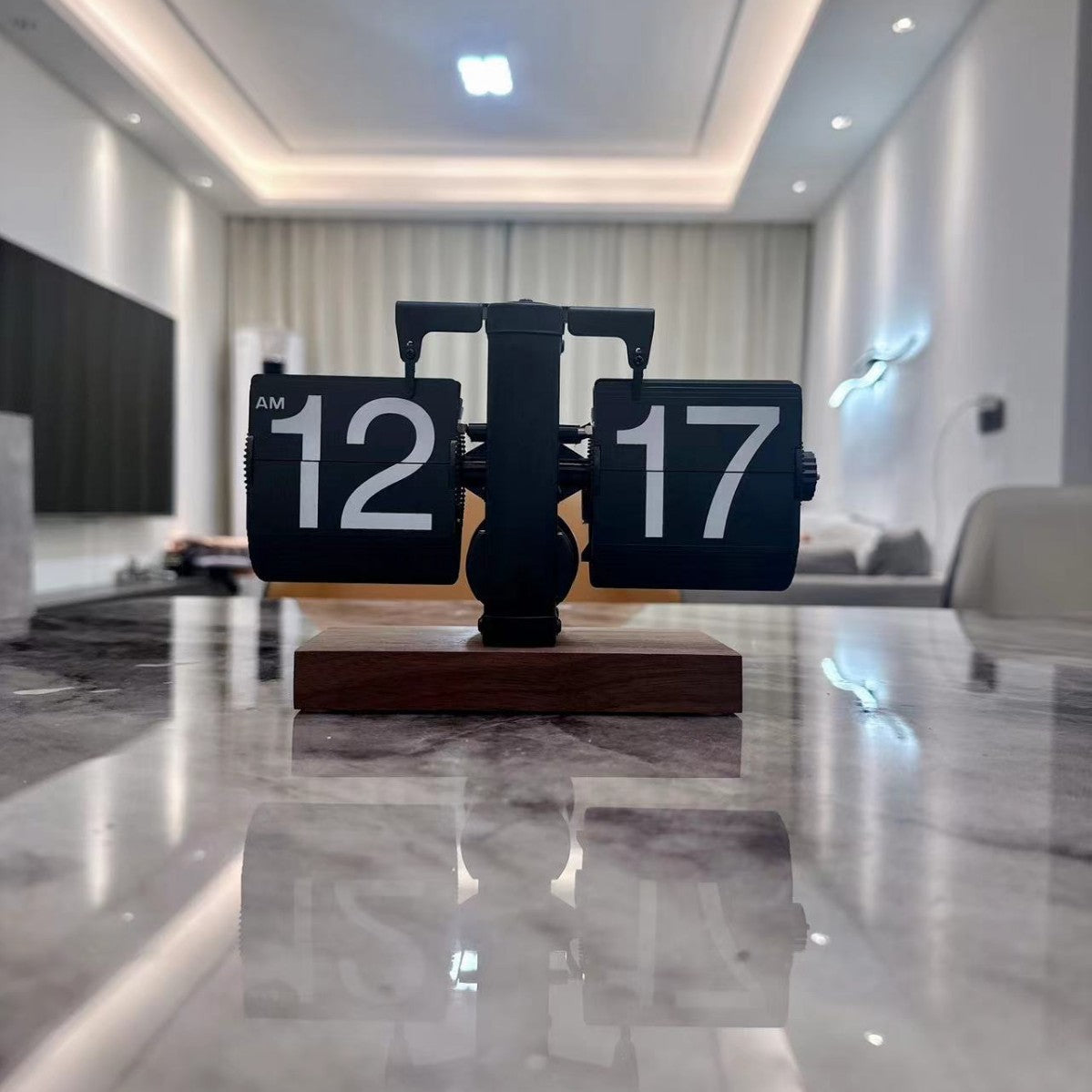 Table clock with digital display on a marble surface in a modern living room.