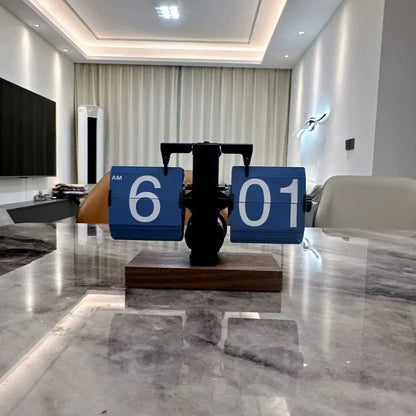 Modern clock on a marble table in a stylish room with decor elements.