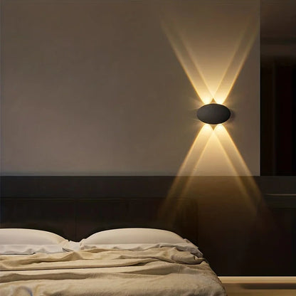 Wall-mounted light fixture casting a warm glow on a bedroom wall.