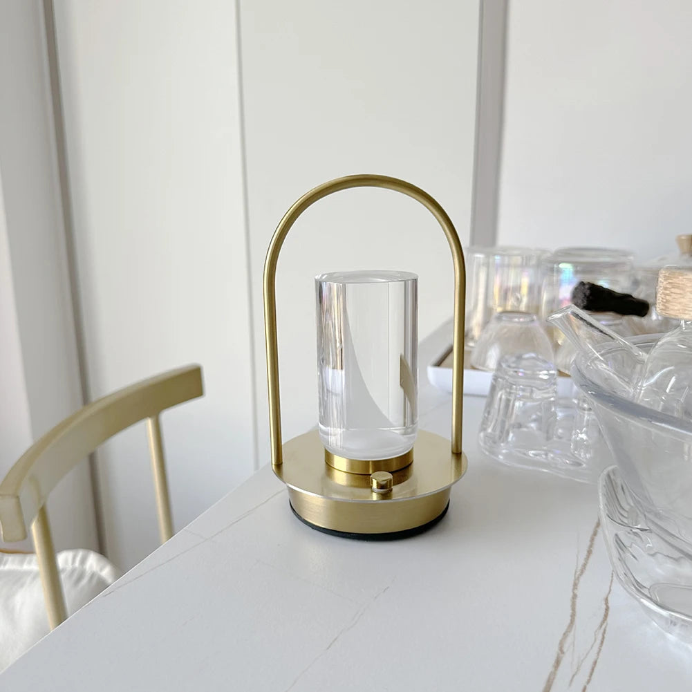 Gold lamp with clear glass shade on a white surface