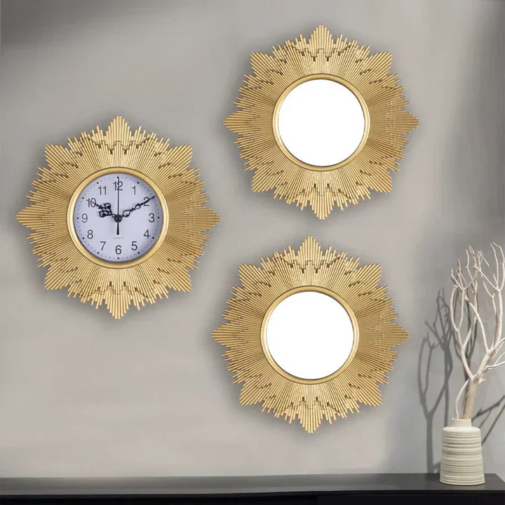 Three gold sunburst wall mirrors on a gray wall with a vase and branches on a shelf.
