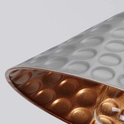 Close-up of a textured container with a metallic interior on a light gray background