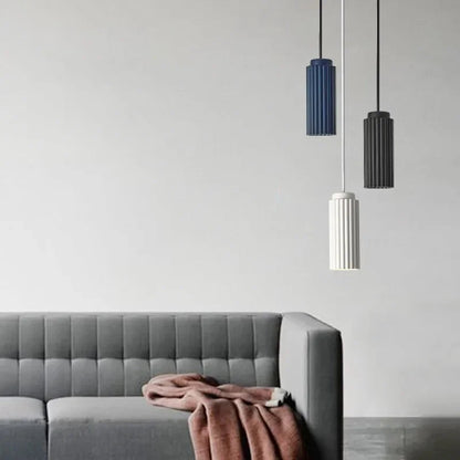Gray sofa with a pink blanket and three pendant lights on a light gray background