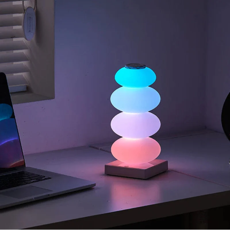 Colorful stacked lamp on a desk next to a laptop