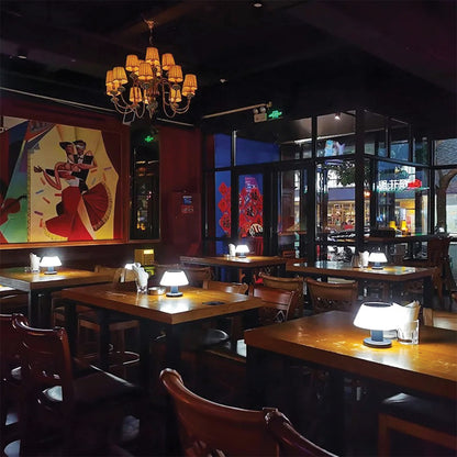 Dining area with tables, chairs, and a chandelier in a restaurant.
