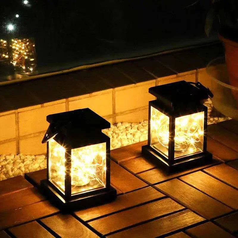 Two solar-powered lanterns on a wooden surface with a dark background
