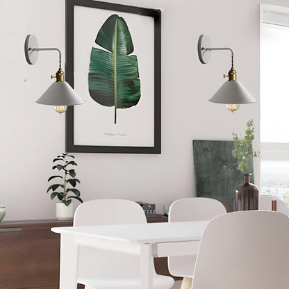 Dining room with a white table and chairs, wall sconces, and a framed leaf print on the wall.