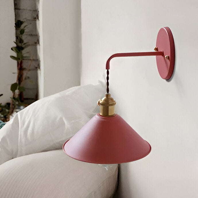 Red wall lamp with gold accent on a white wall