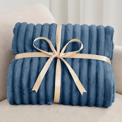 Blue blanket with a beige ribbon on a light-colored couch