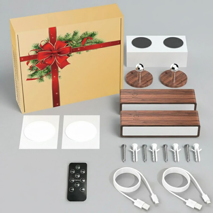 Home theater setup kit with Christmas-themed box, speakers, remote control, and cables on a gray background.
