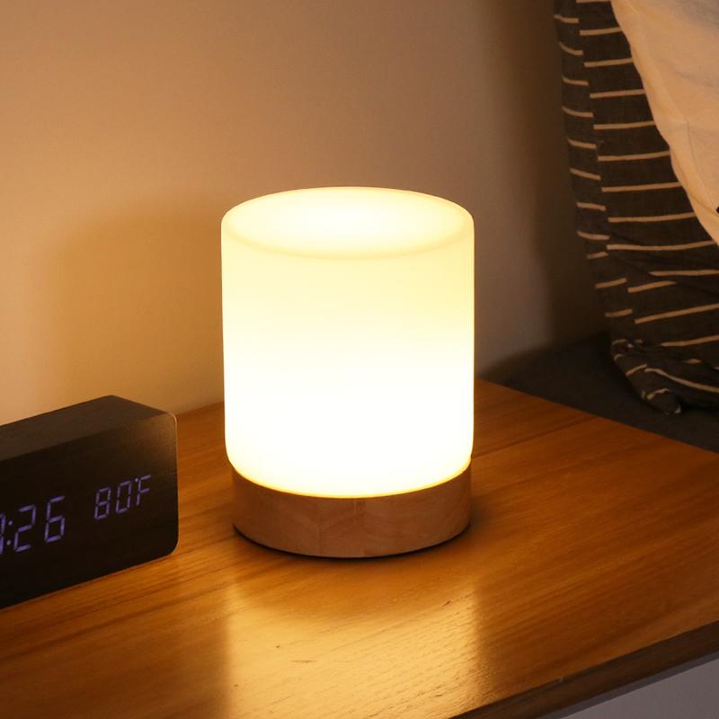 Small night light on a bedside table next to an alarm clock.
