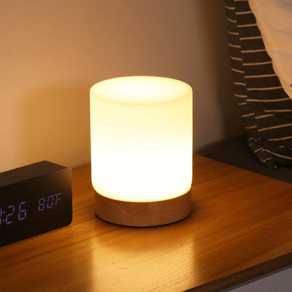 Small night light on a bedside table next to an alarm clock.