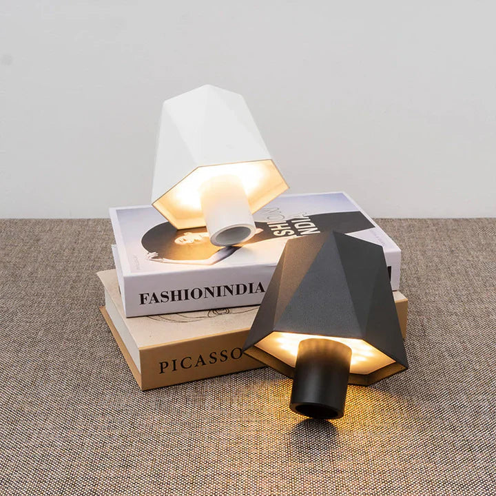 Geometric wall lamp with a white shade on top of books