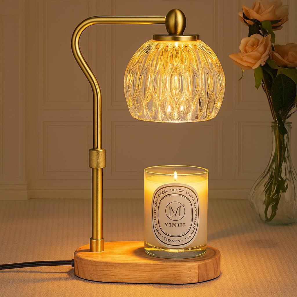 Decorative lamp with glass shade and wooden base next to a lit candle and vase of flowers.