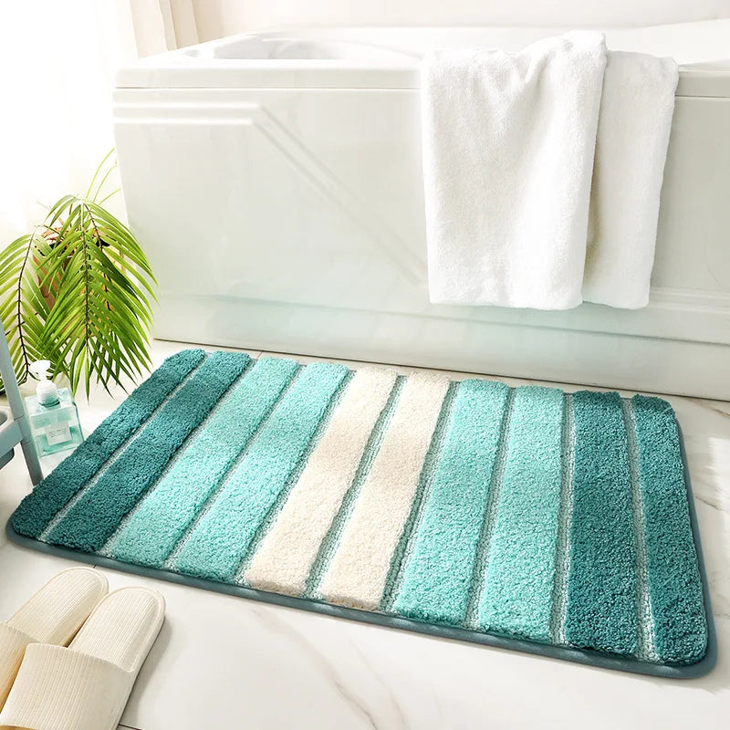 Striped bath mat with green and blue gradient on a white bathtub