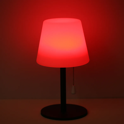 Table lamp with a red gradient shade on a dark background