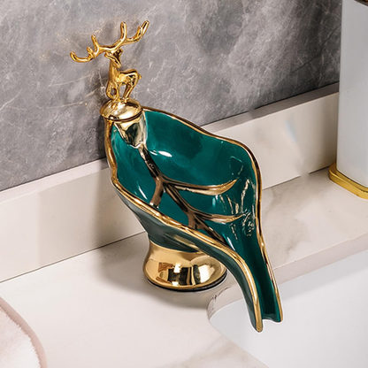Decorative faucet with gold and green design on a marble surface