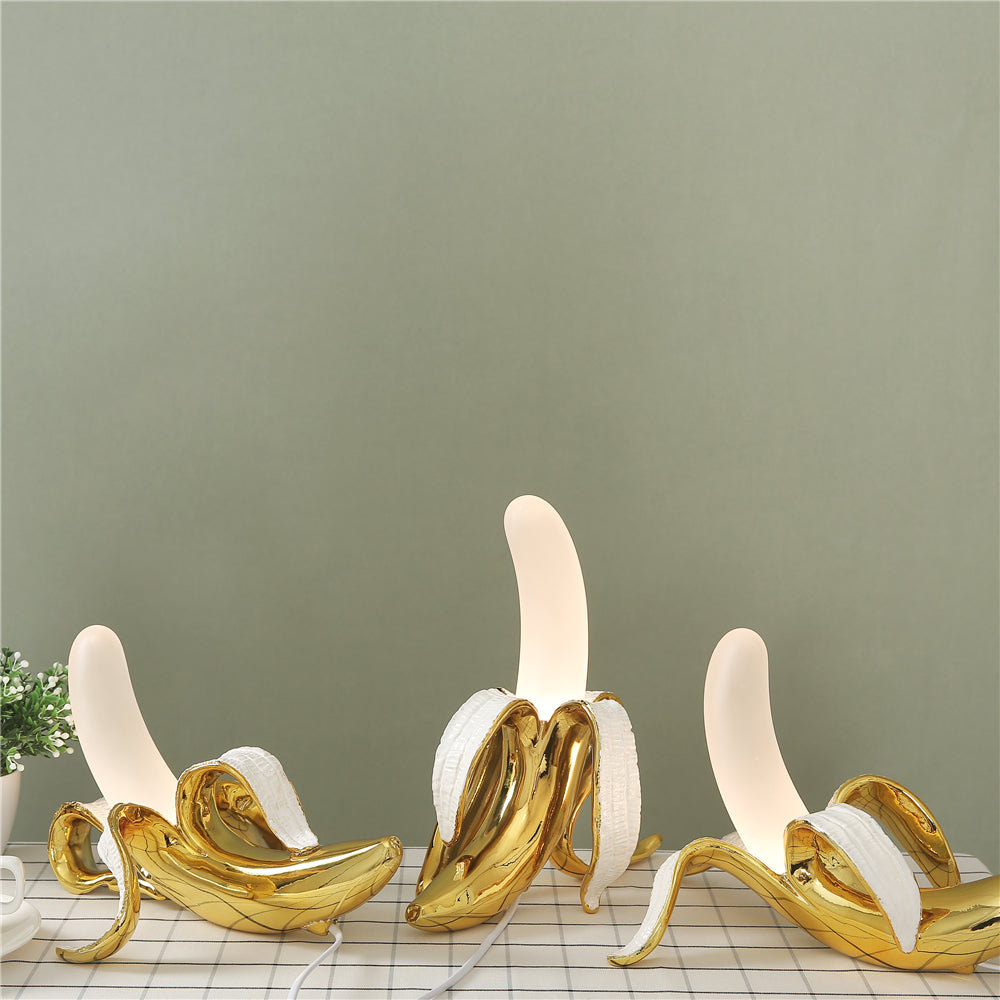 Gold banana-shaped lamps on a checkered surface with a green wall background